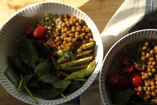 Frühlingshafte Quinoa-Bowl mit Avocado, Babyspinat, Kichererbsen und frischer Minze in einer hellen Schale serviert